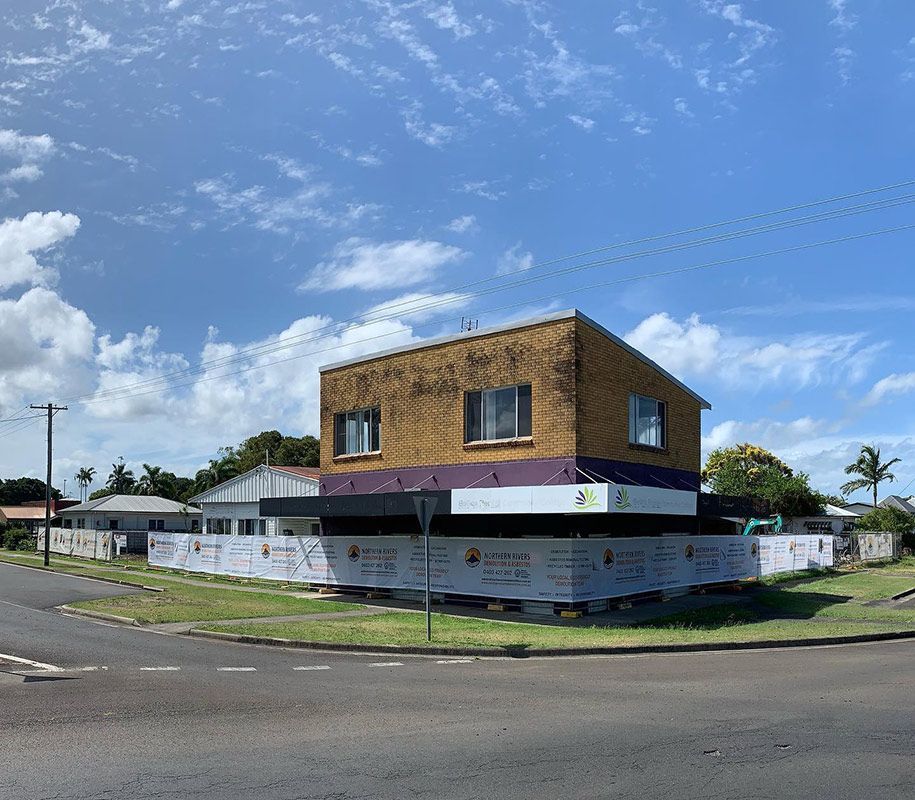 A Brick Building with A Purple Awning Is Sitting on The Corner of A Street — Northern Rivers Demolition & Asbestos in Casino, NSW