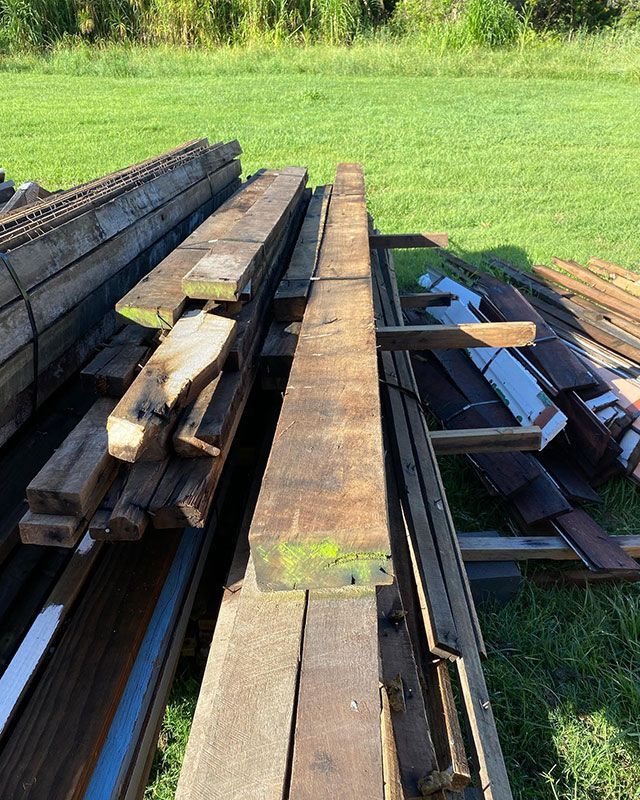 A Pile of Wood Is Sitting on Top of A Grassy Field — Northern Rivers Demolition & Asbestos in Casino, NSW