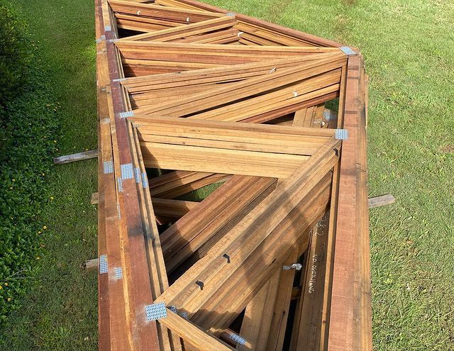 A Stack of Wooden Frames Sitting on Top of A Lush Green Field — Northern Rivers Demolition & Asbestos in Ballina, NSW