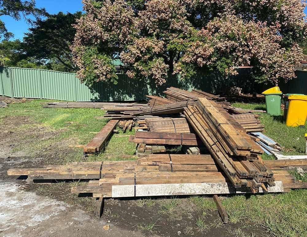 A Pile of Wood Is Laying on The Ground in A Yard — Northern Rivers Demolition & Asbestos in Tweed Heads, NSW