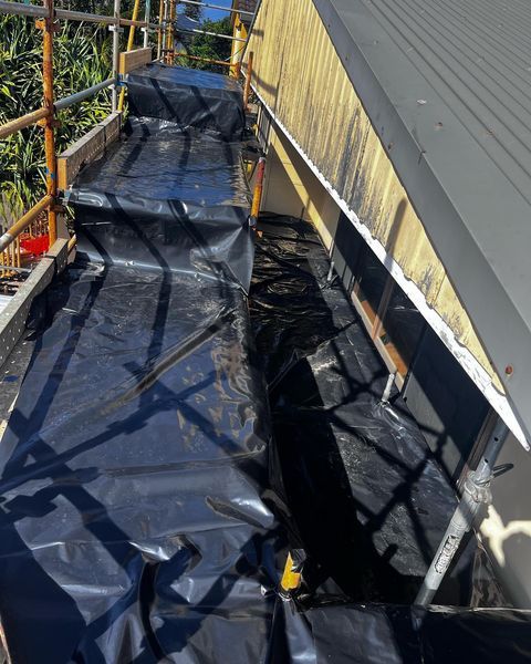 A Black Tarp Is Covering the Side of A Building — Northern Rivers Demolition & Asbestos in Skennars Head, NSW