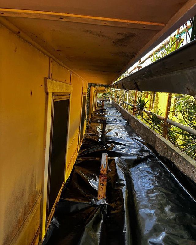 A Long Hallway with A Lot of Black Plastic Covering It — Northern Rivers Demolition & Asbestos in Casino, NSW
