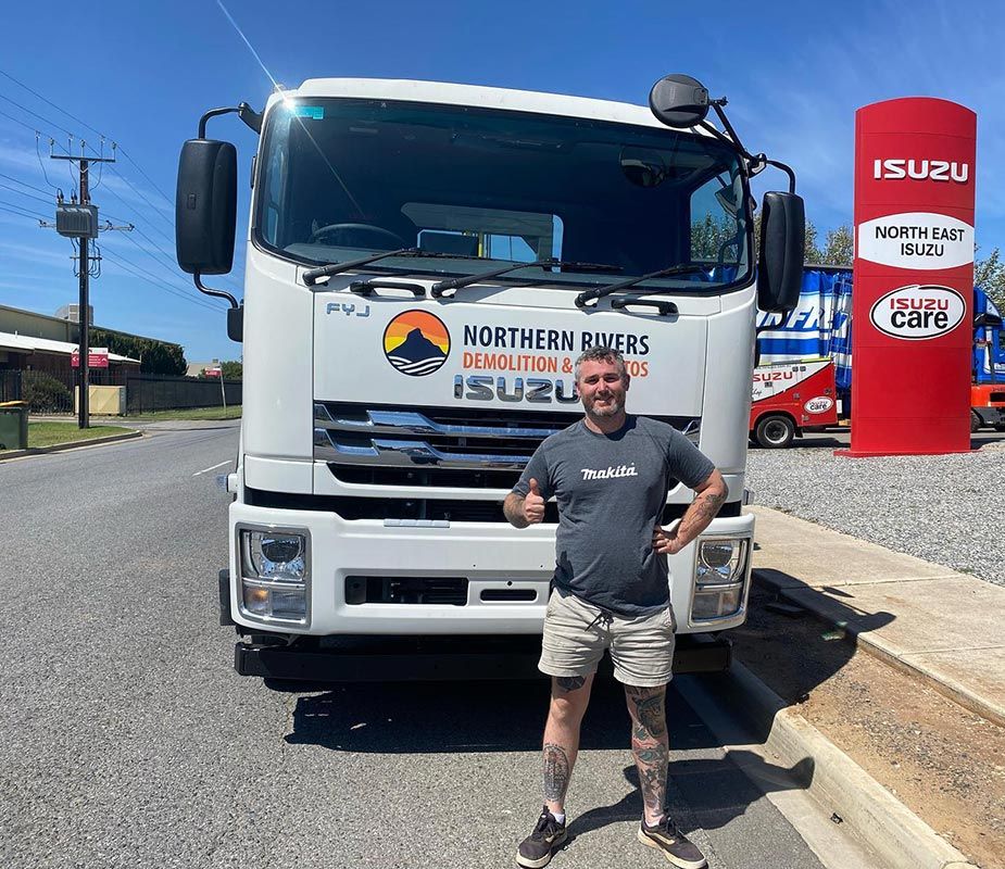 A Man Is Standing in Front of A White Truck — Northern Rivers Demolition & Asbestos in Skennars Head, NSW