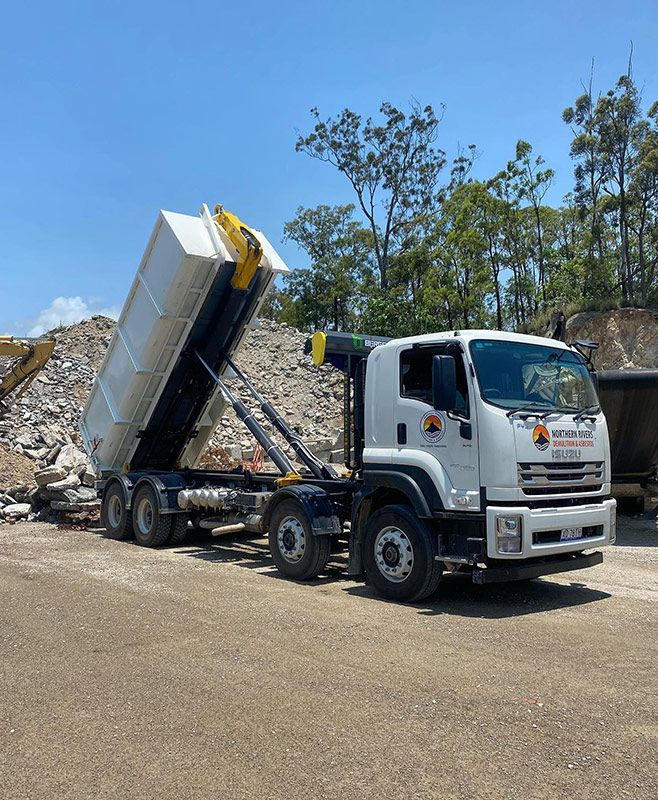A Dump Truck Is Parked in Front of A Pile of Rocks — Northern Rivers Demolition & Asbestos in Murwillumbah, NSW