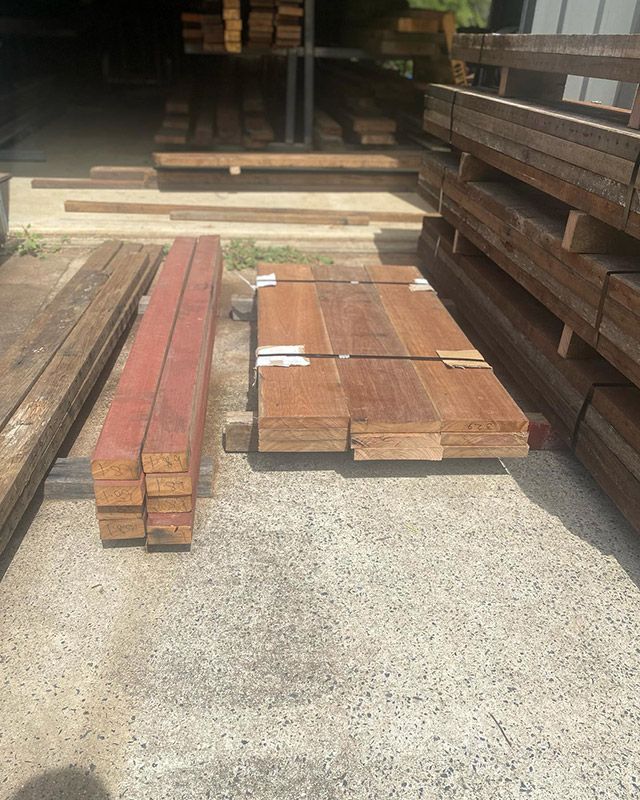 A Pile of Wood Is Sitting on The Ground in A Warehouse — Northern Rivers Demolition & Asbestos in Tweed Heads, NSW