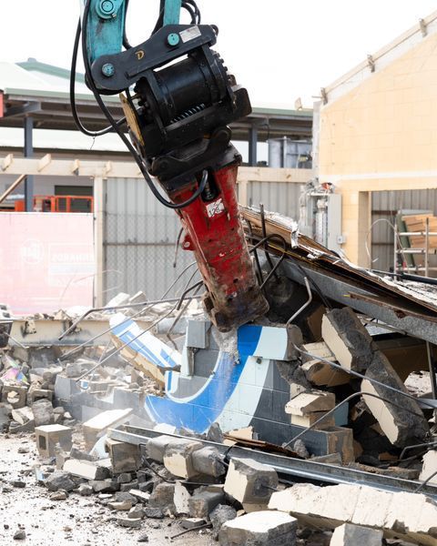 A Building Is Being Demolished by A Machine — Northern Rivers Demolition & Asbestos in Lismore, NSW
