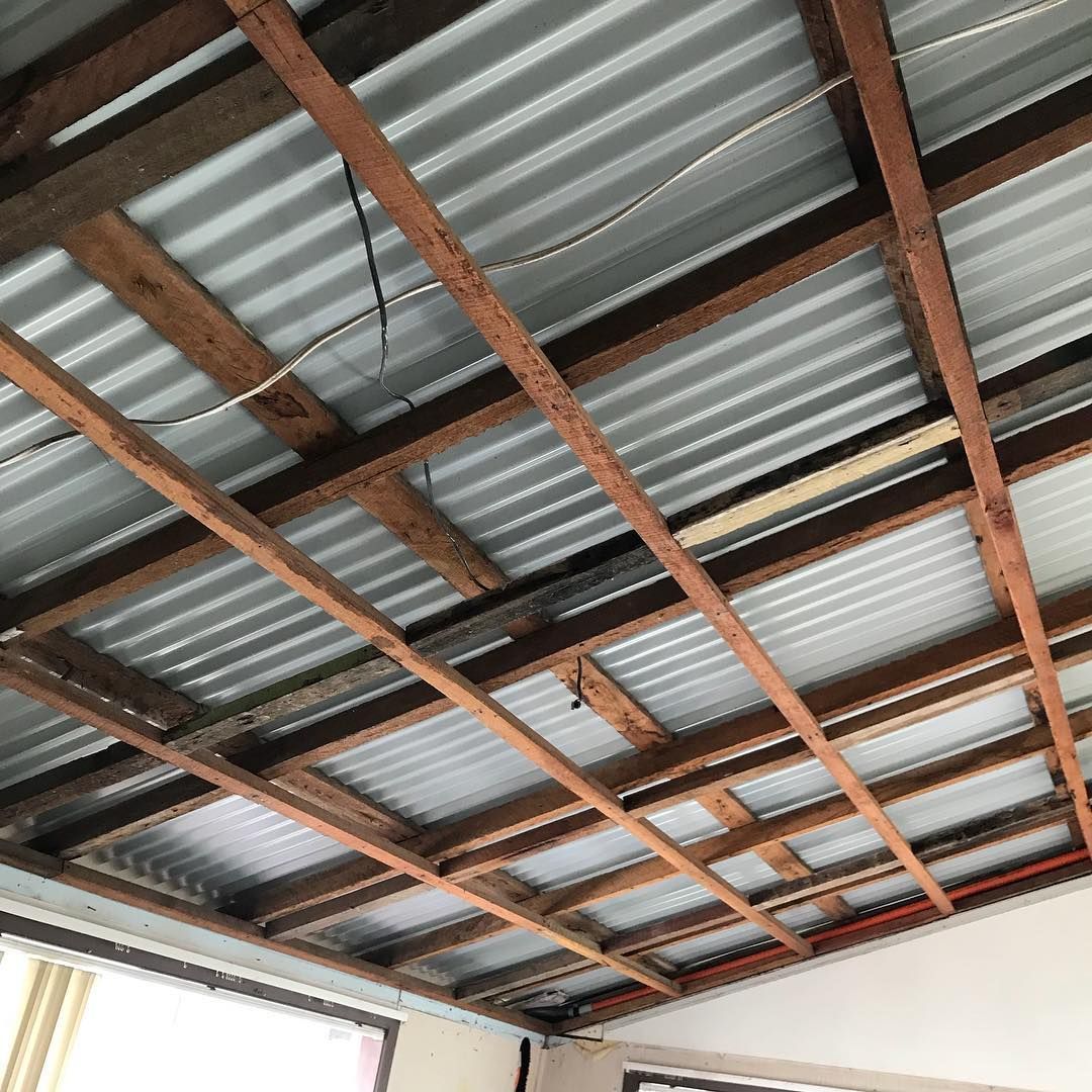 A Ceiling with Wooden Beams and A Metal Roof in A Room — Northern Rivers Demolition & Asbestos in Skennars Head, NSW