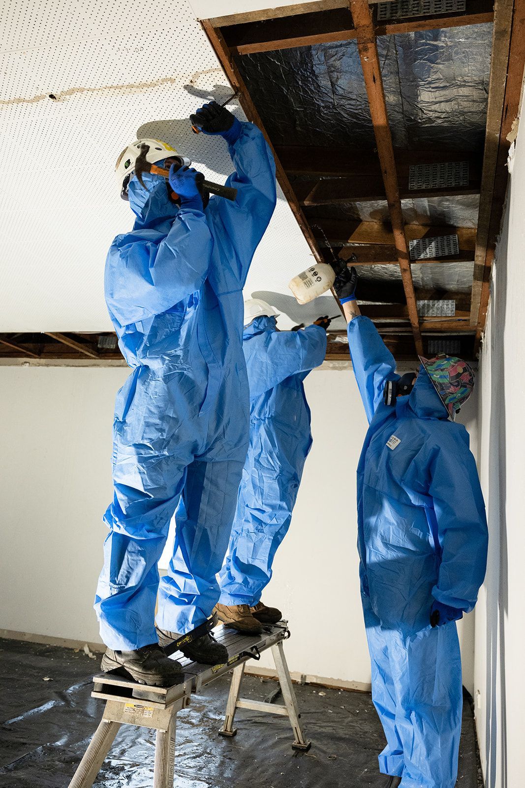 Men in Blue PPE Gear Removing Asbestos in Roof — Northern Rivers Demolition & Asbestos in Skennars Head, NSW