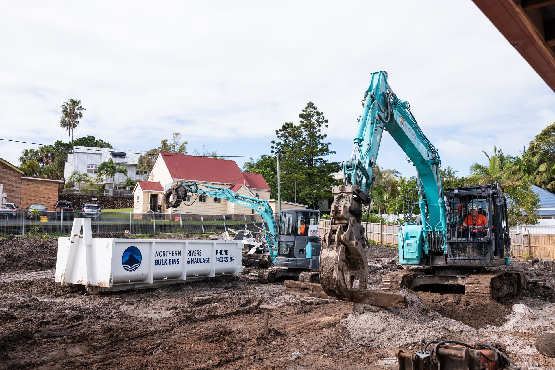 A Truck and An Excavator Are Parked in A Grassy Field — Northern Rivers Demolition & Asbestos in Skennars Head, NSW