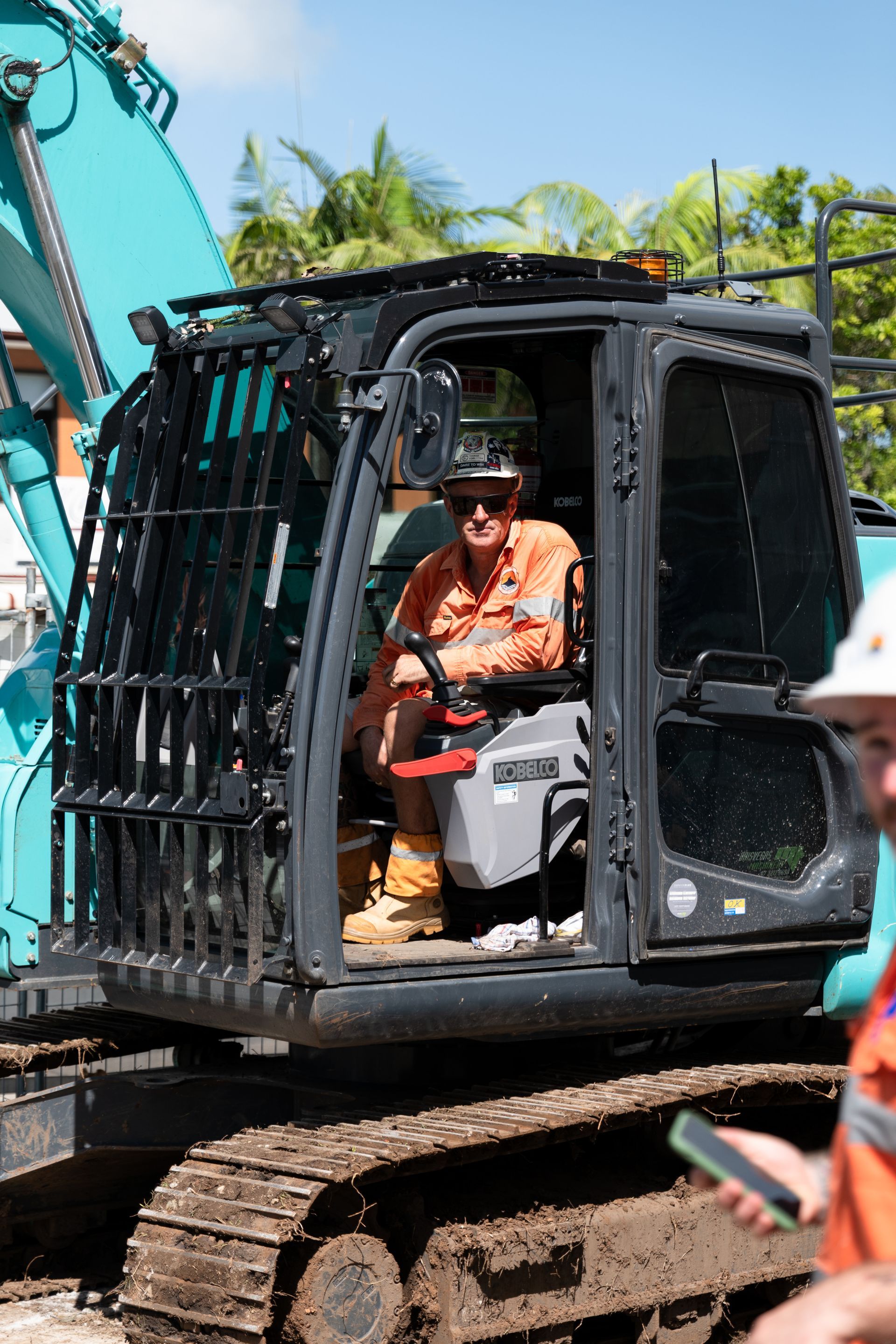 An Excavator Is Digging a Hole in The Ground Next to A Pool — Northern Rivers Demolition & Asbestos in Skennars Head, NSW
