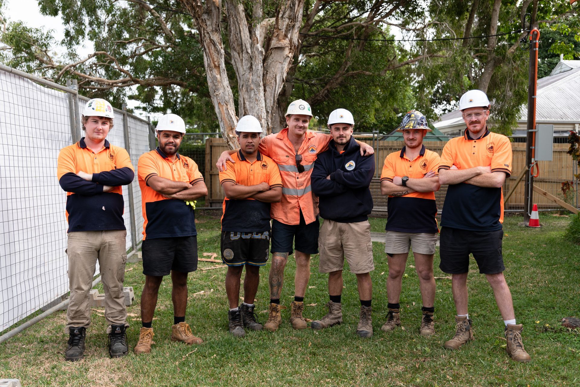 A group of construction workers are posing for a picture.
