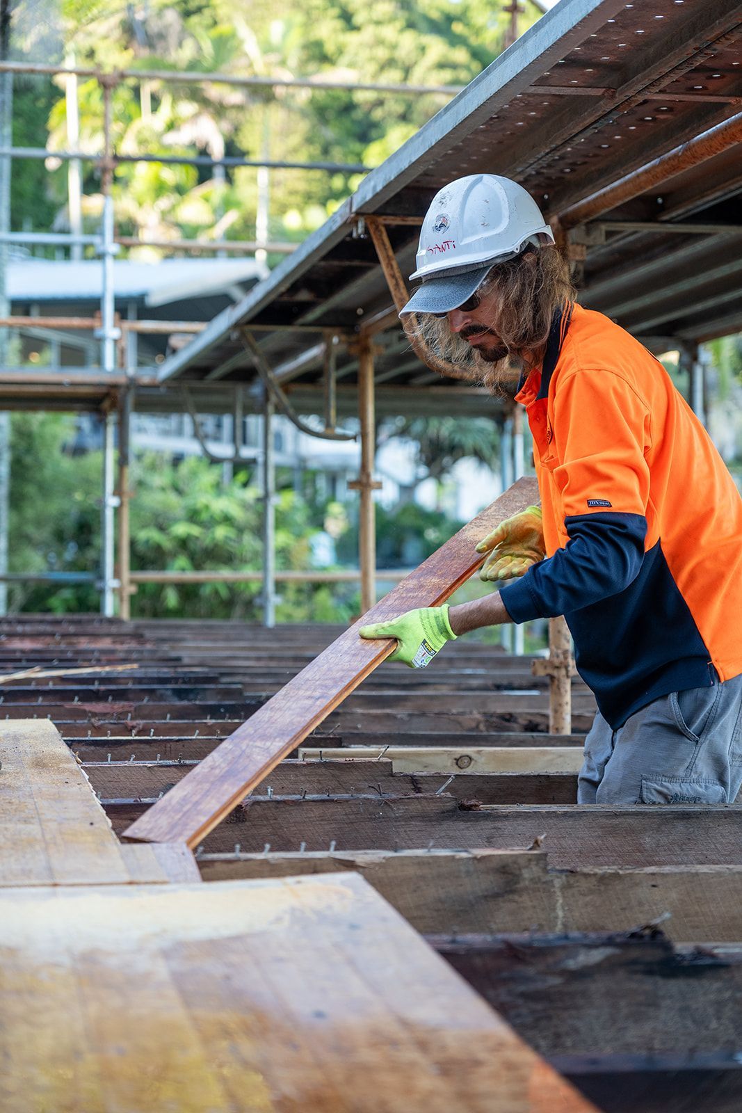 Man Laying Down Recycled Timber On Deck — Northern Rivers Demolition & Asbestos in Skennars Head, NSW