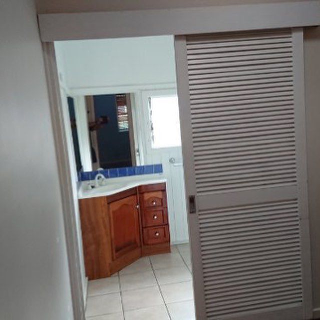 A Bathroom with A Sliding Door and A Sink With Cabinet — Northern Rivers Demolition & Asbestos in Byron Bay, NSW