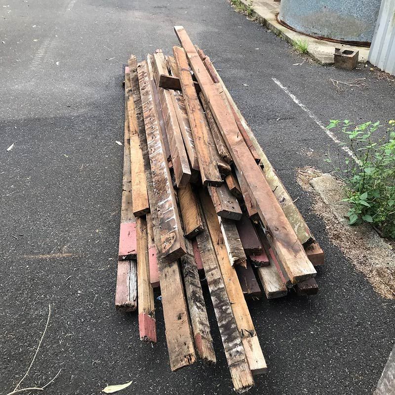 A Pile of Wood Is Sitting on The Side of The Road — Northern Rivers Demolition & Asbestos in Skennars Head, NSW
