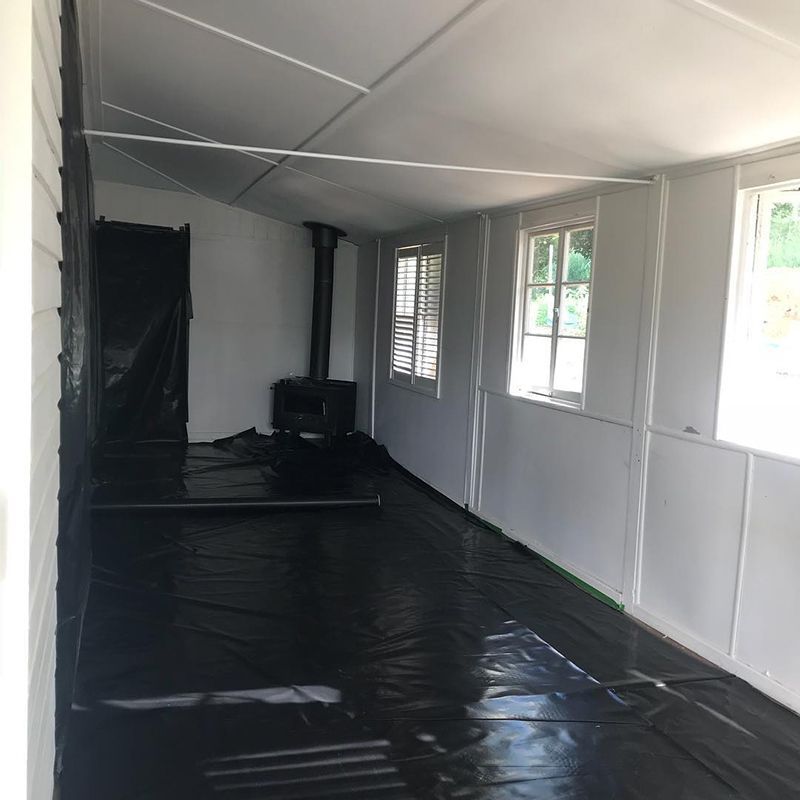 A Large Empty Room with A Black Floor and White Walls — Northern Rivers Demolition & Asbestos in Grafton, NSW
