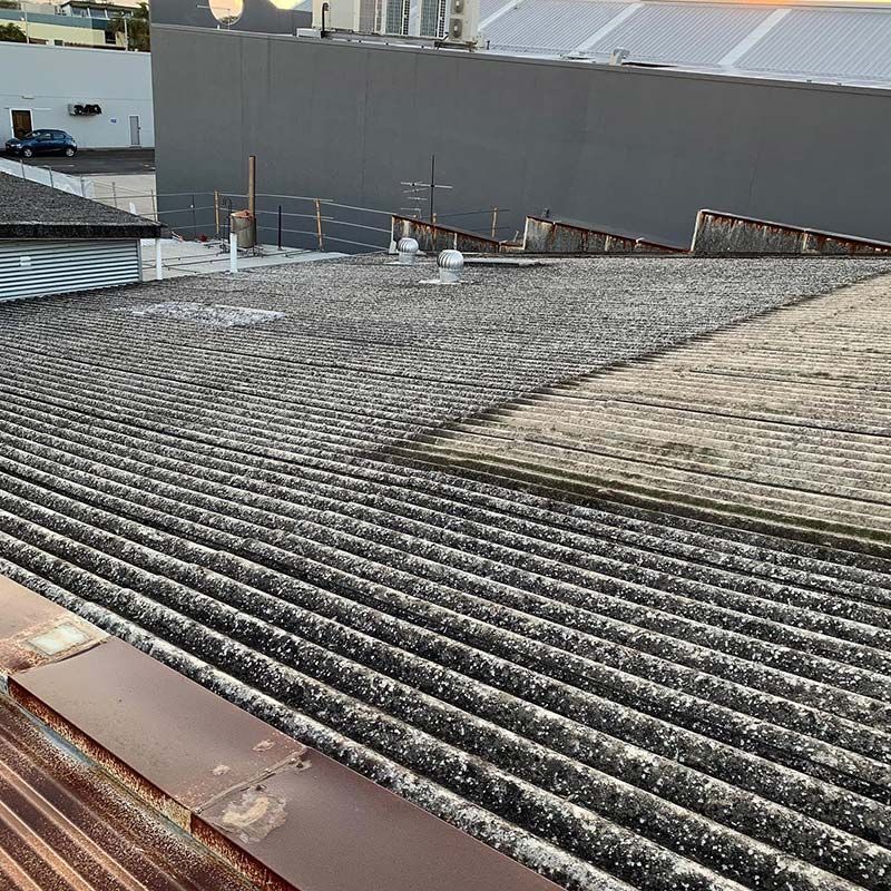 A Close up Of a Roof with A Building in The Background — Northern Rivers Demolition & Asbestos in Byron Bay, NSW
