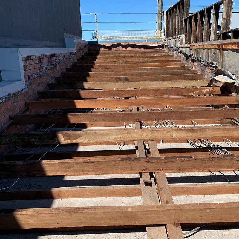 A Row of Wooden Beams on A Concrete Floor — Northern Rivers Demolition & Asbestos in Murwillumbah, NSW