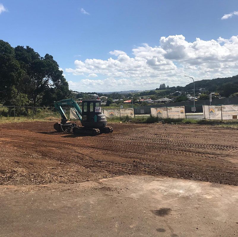A Small Excavator Is Working in A Dirt Field — Northern Rivers Demolition & Asbestos in Lismore, NSW