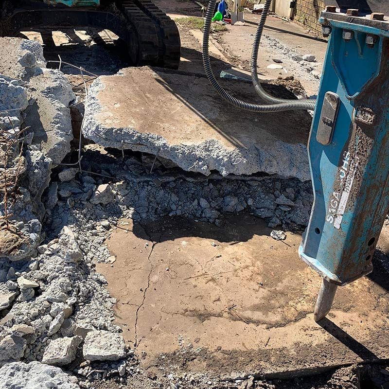 A Large Piece of Concrete Is Being Demolished by A Machine — Northern Rivers Demolition & Asbestos in Murwillumbah, NSW