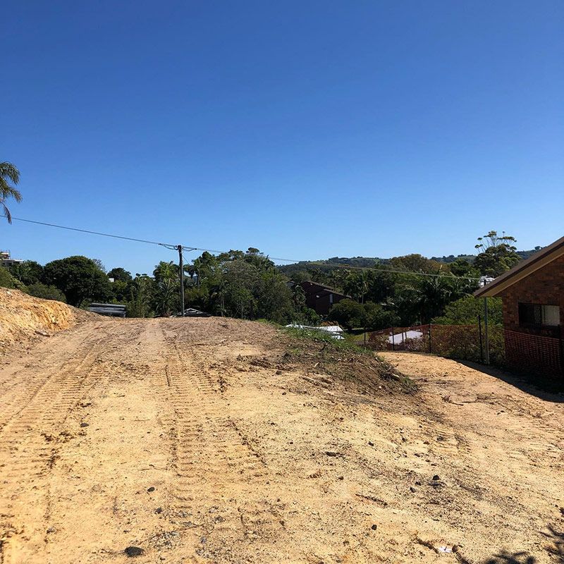 A Dirt Road with A House in The Background on A Sunny Day — Northern Rivers Demolition & Asbestos in Murwillumbah, NSW