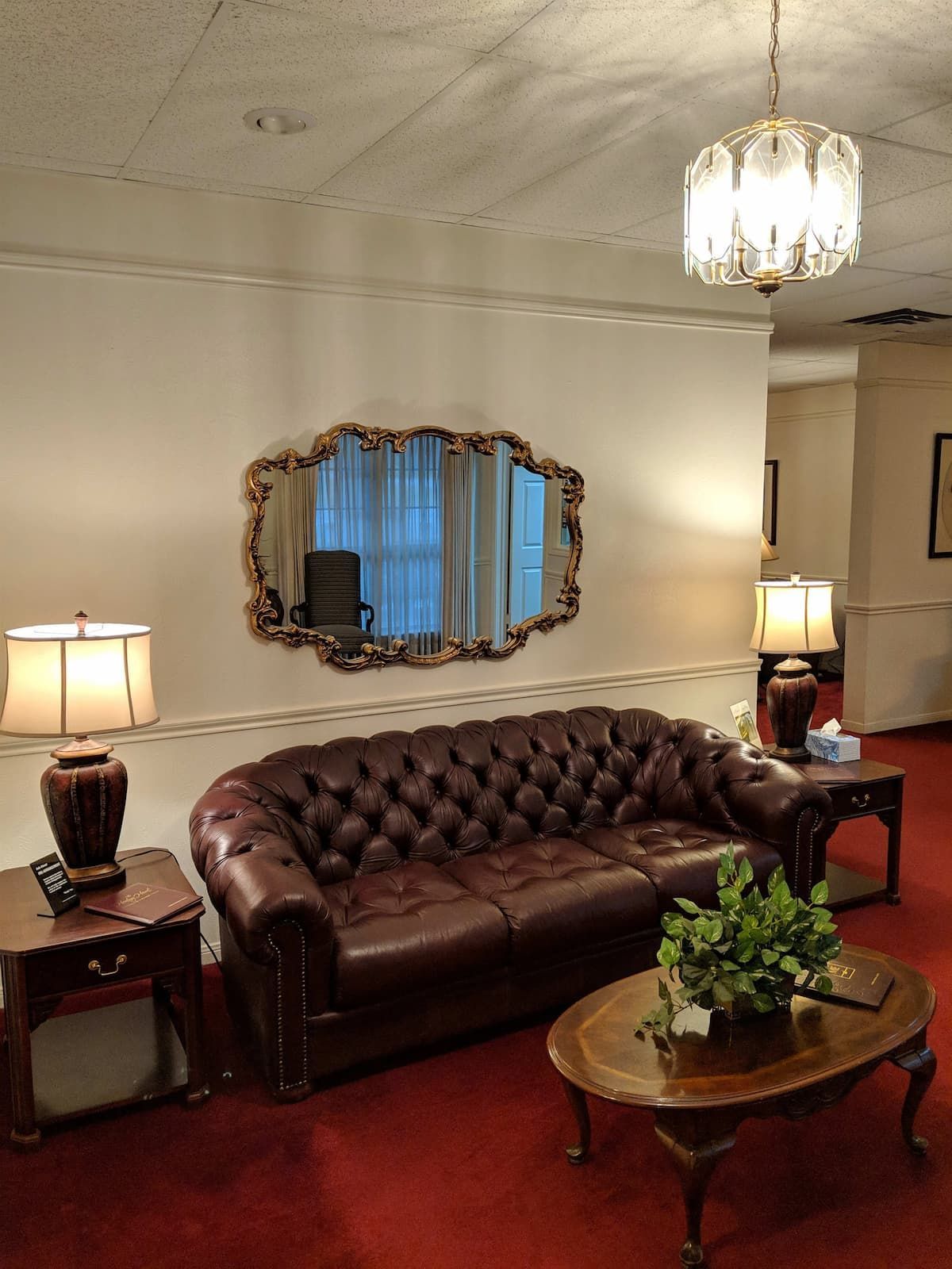 a living room with a brown couch and a mirror on the wall