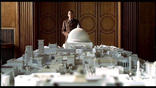 A man is standing in front of a model of a city