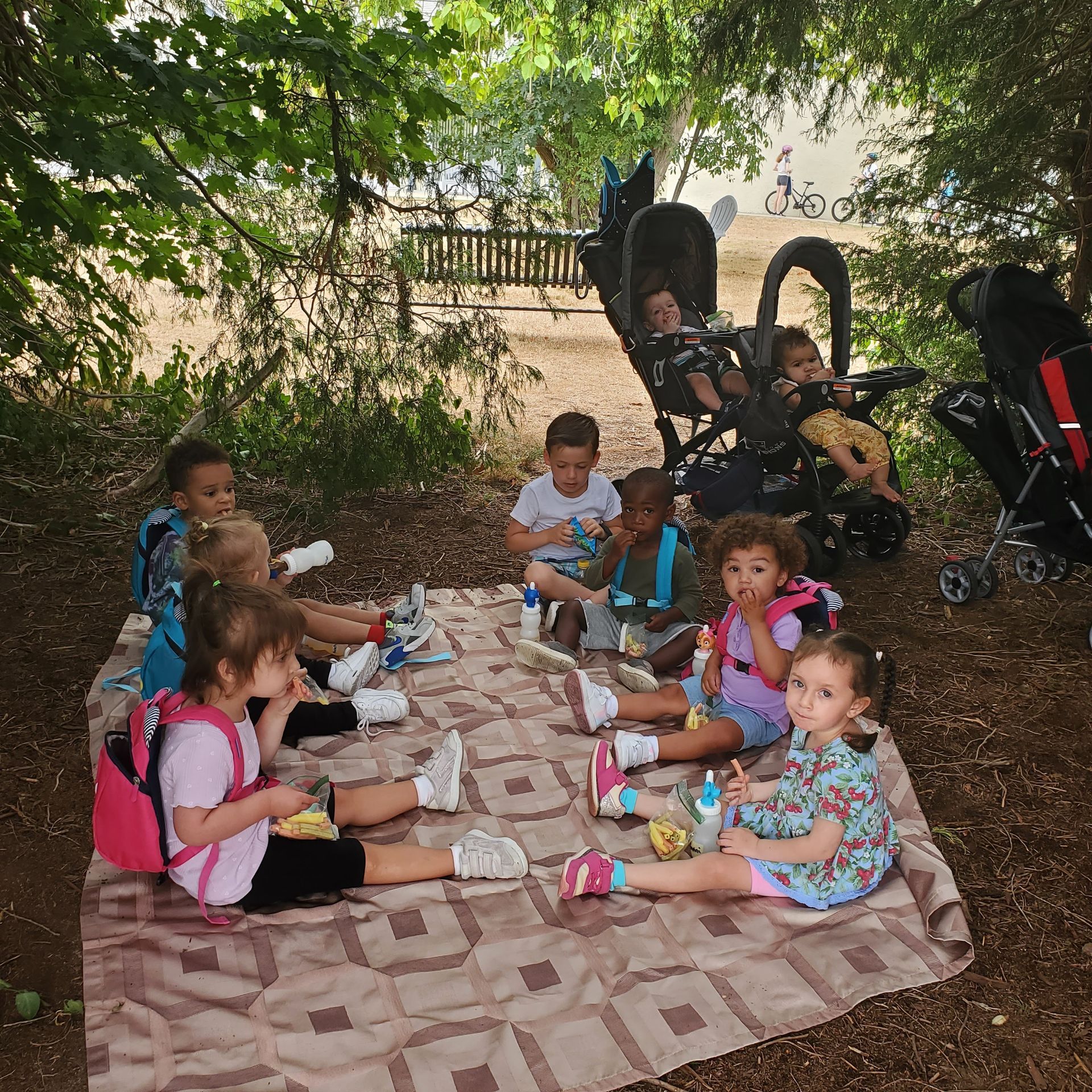 Children shoveling snow with shovels in a snowy backyard.