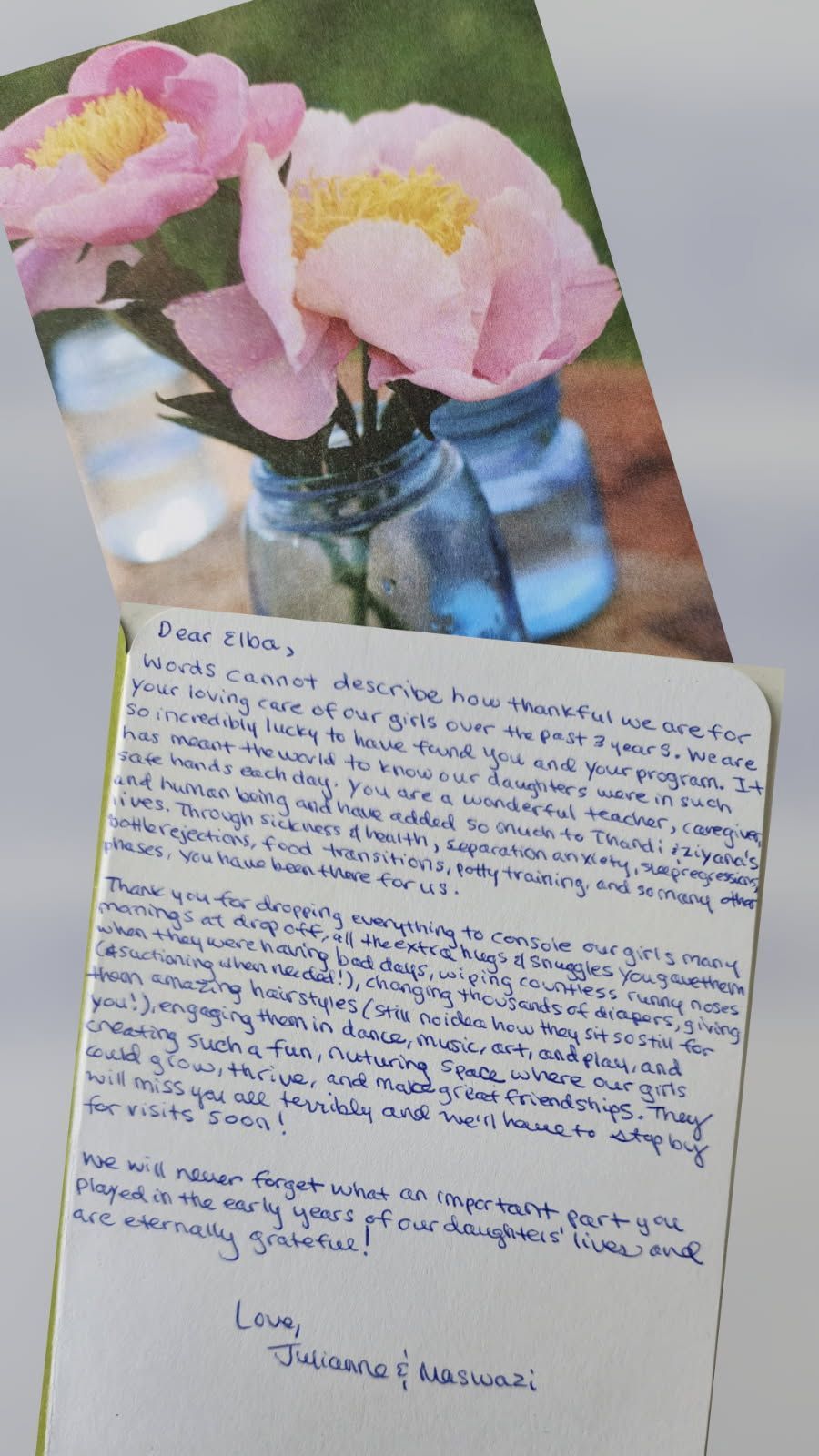 Handwritten letter with pink flowers in blue jars on top.