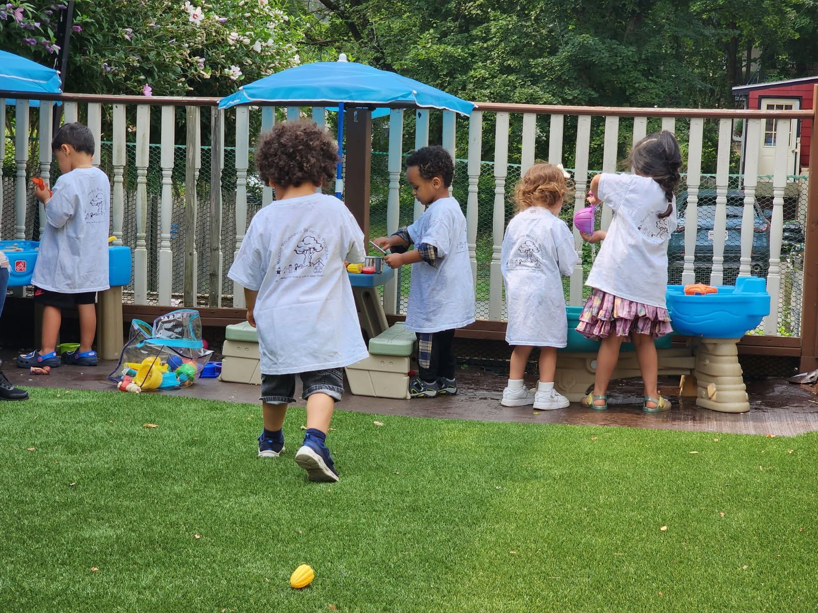 Babies and caregiver playing with blocks on the floor.