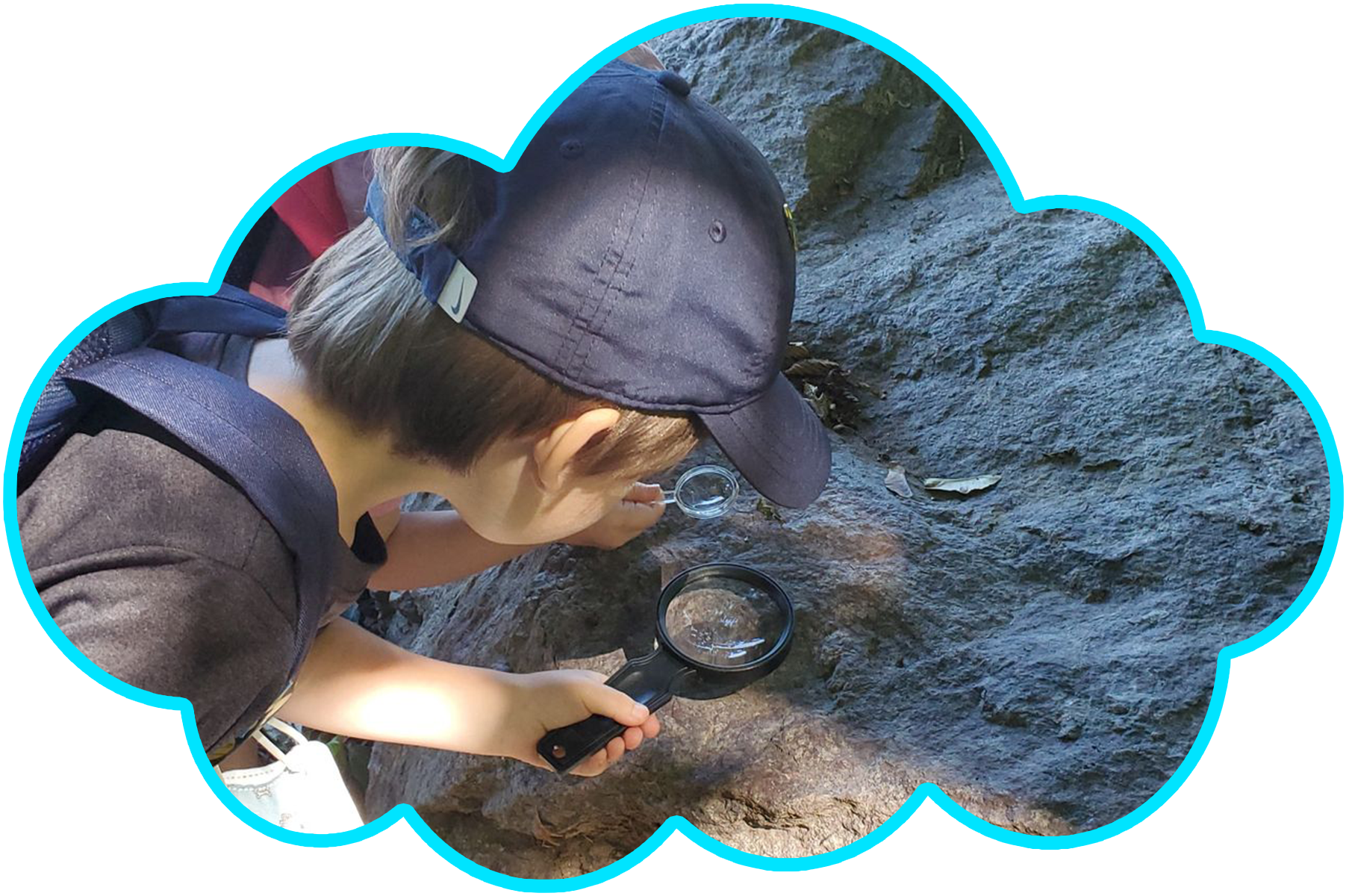 Children playing in a splash pad on a sunny day; green grass, blue sky.
