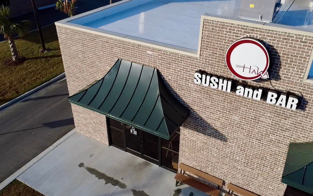 Sushi and Bar restaurant exterior with brick walls, awning, and signage.