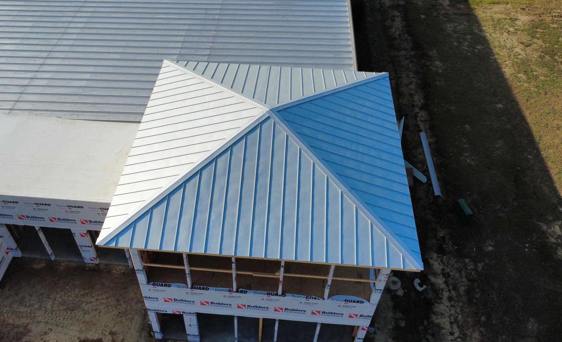 Overhead view of a building with a silver metal roof and an angular, four-sided section.