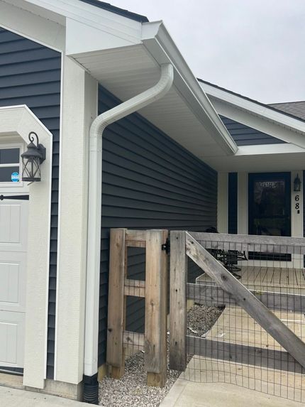 A house with a white gutter on the side of it