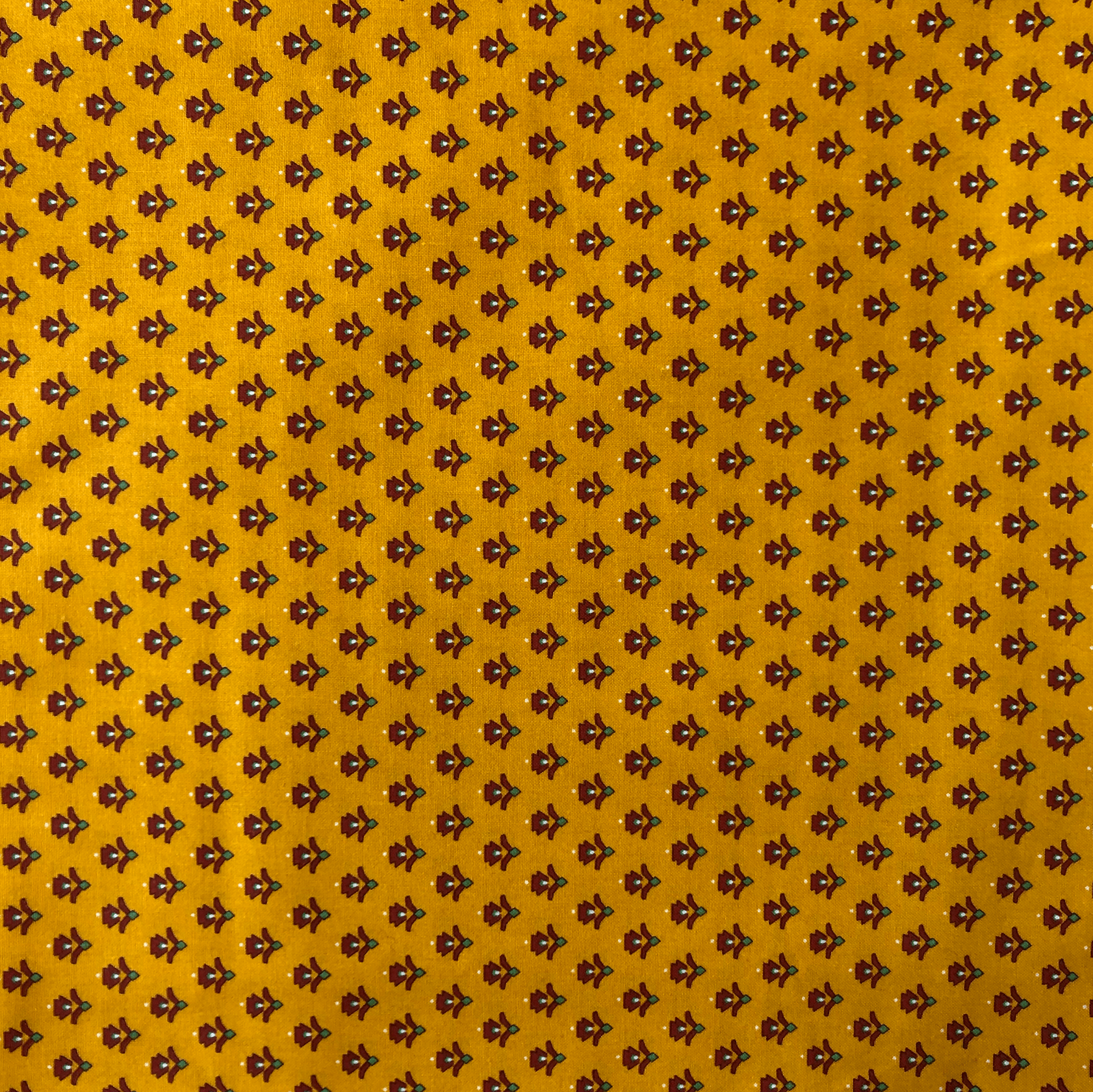Tissu jaune avec petit motif floral marron répétitif.
