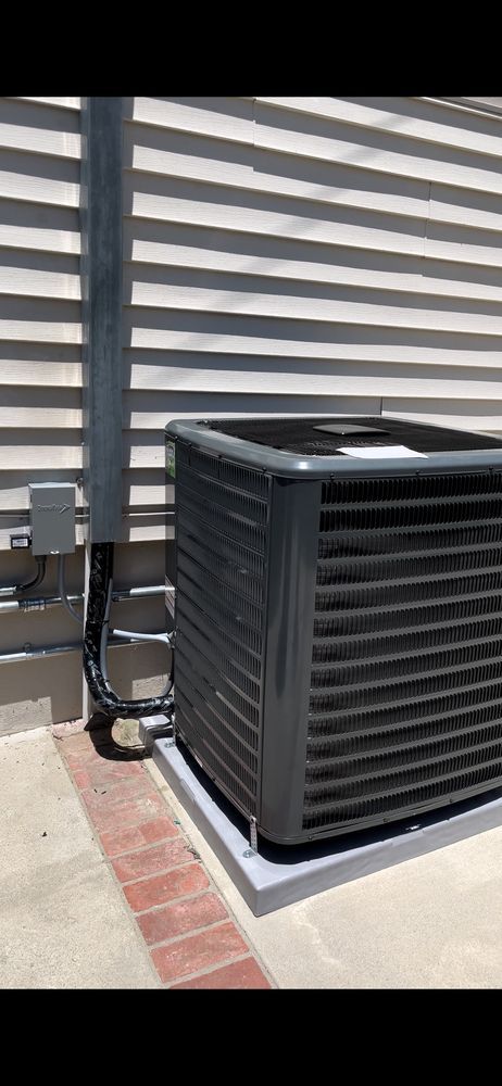 An outdoor air conditioning unit with a metal casing next to a building wall.