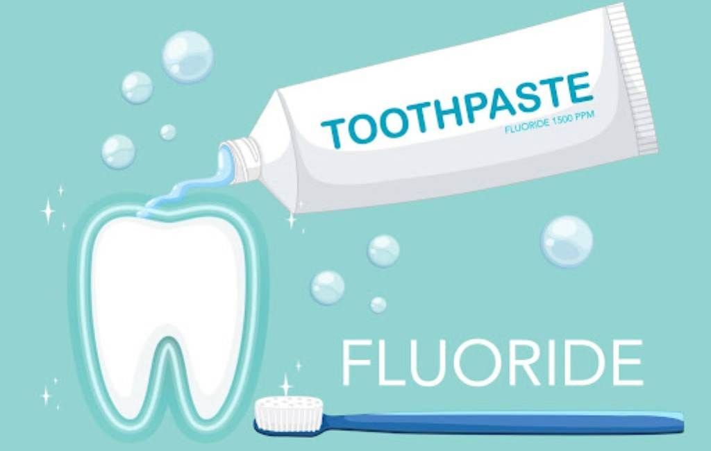 Toothpaste tube and toothbrush with fluoride label on a blue background