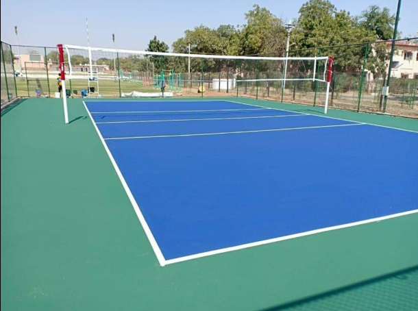 “Outdoor volleyball court with blue center surface, green borders, and a net after a court builder service in Tucson, AZ”