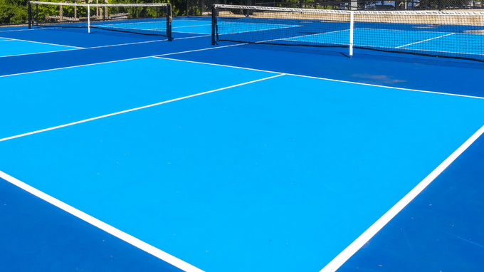 “Bright blue pickleball court with sharp white lines and a smooth playing surface after a court builder service in Tucson, AZ”