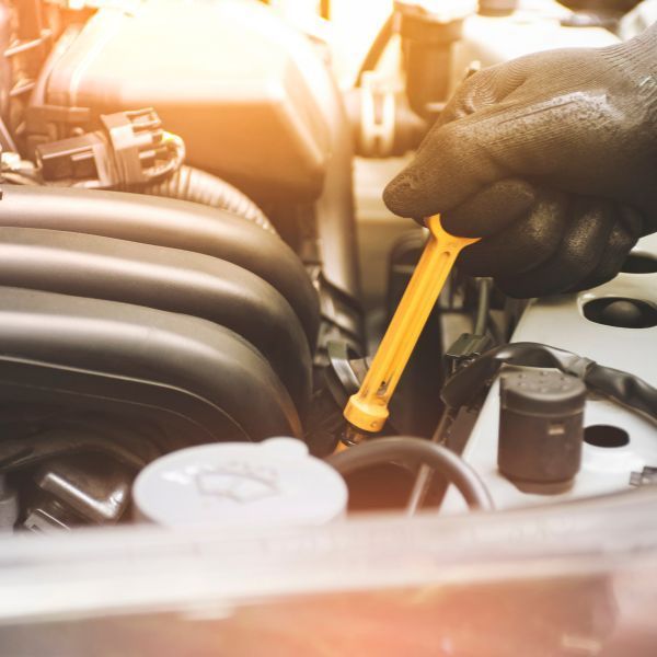 technician pulling a dipstick from an engine