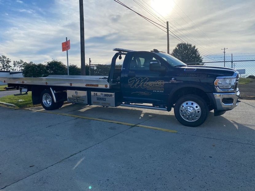 A blue tow truck is parked on the side of the road.