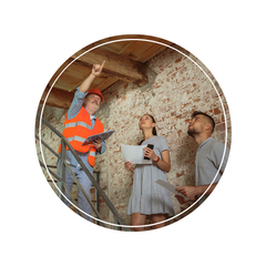 A man and two women are looking up at the ceiling of a building.