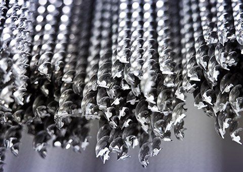 A close up of a bunch of metal screws hanging from a ceiling.