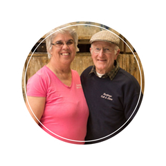 A man and a woman are posing for a picture and the woman is wearing a pink shirt