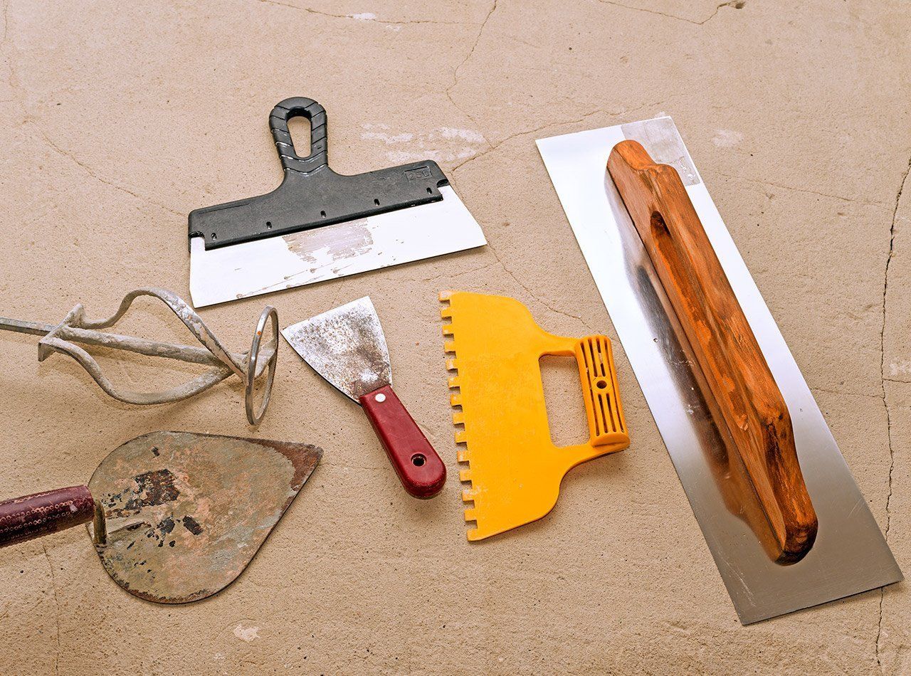 A bunch of tools are laying on a wooden surface
