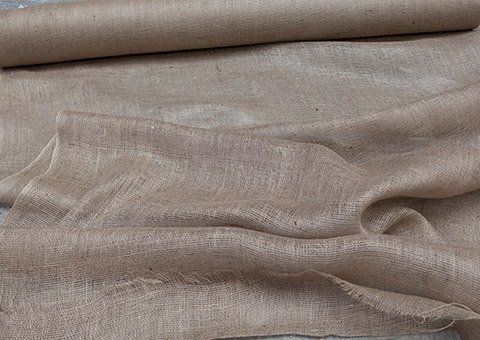 A roll of burlap fabric is laying on a table.