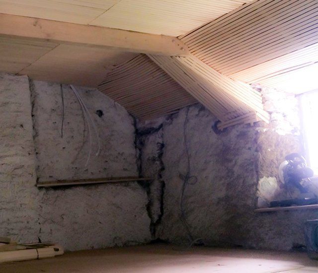 An empty room with a wooden ceiling and a window