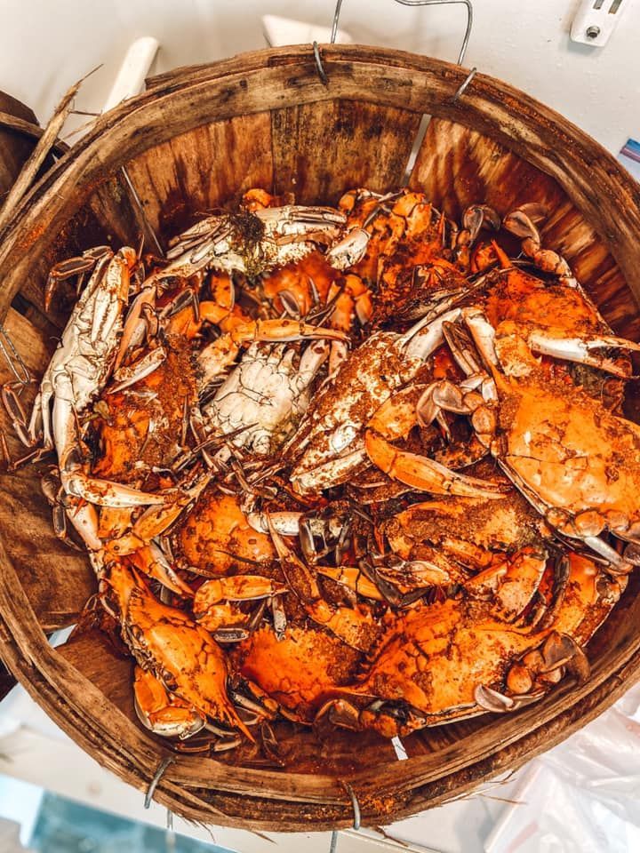 A wooden bushel basket filled with steamed, seasoned blue crabs.