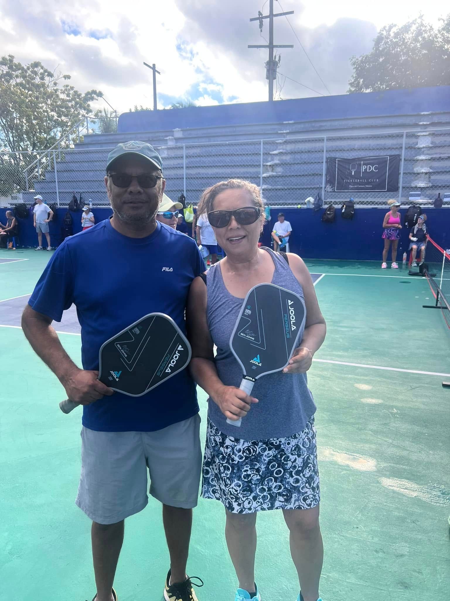 A man in a blue shirt that says rseq is playing pickleball  at the Playa Del Carmen Pickleball Club in Playa Del Carmen, Mexico