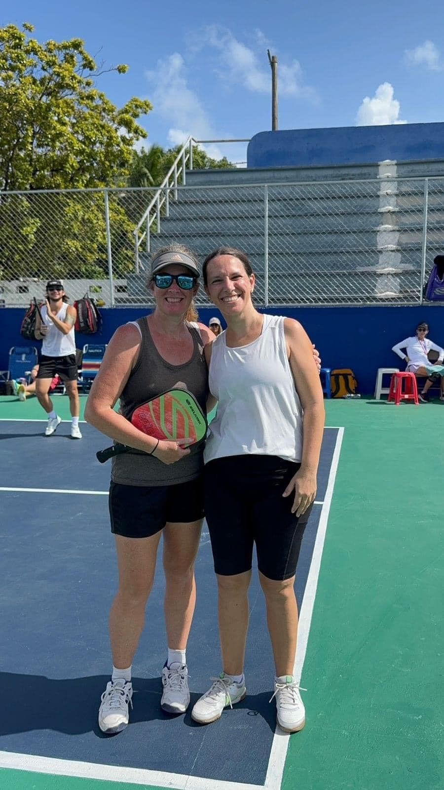 A man and a woman are playing pickleball on a court at the Playa Del Carmen Pickleball Club in Playa Del Carmen, Mexico