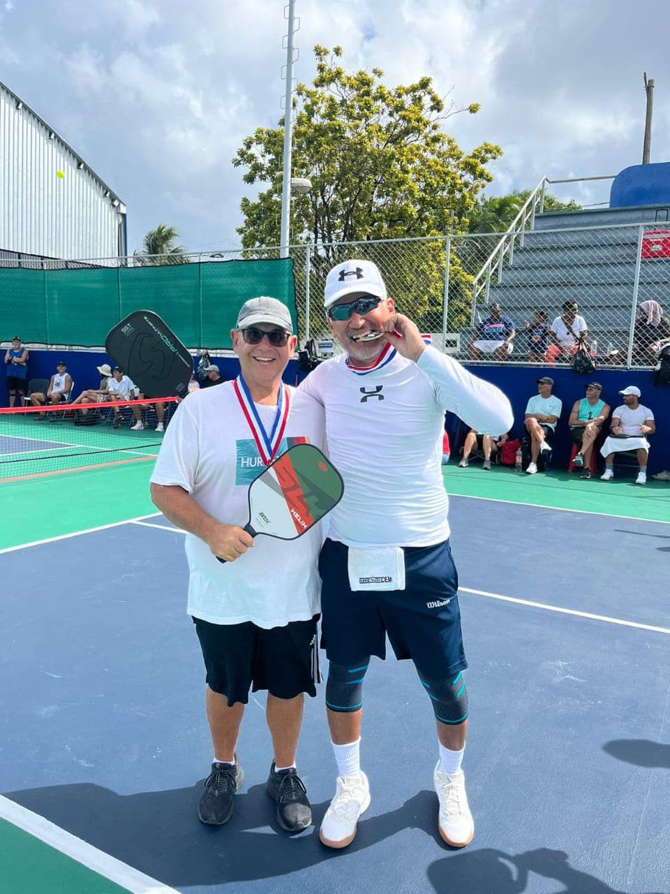 Two men standing in front of a PDC pickleball sign